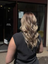 femme posant devant un salon de coiffure